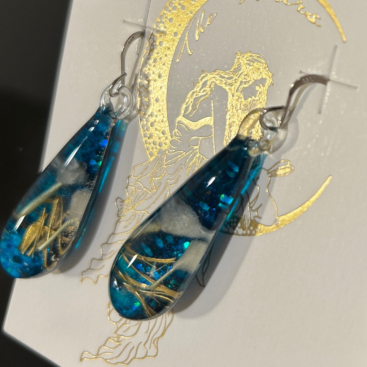 Handmade botanical dichroic glass drop earrings 2.1 inches long with real dried grass straws suspended in blue glass on sterling silver ear wires