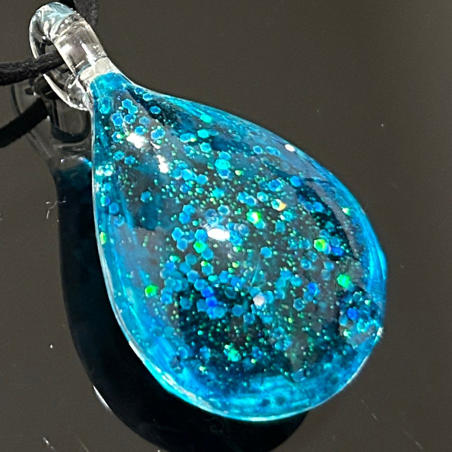 Handmade botanical dichroic glass teardrop pendant 2 inches with real dried grass straws suspended inside blue glass on 21 inch cloth chain