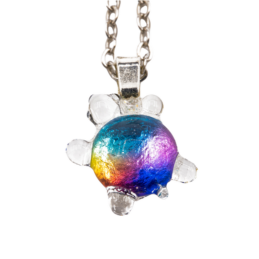 Handmade dichroic glass turtle pendant 1 inch showing color-shifting rainbow effects in blues purples oranges greens