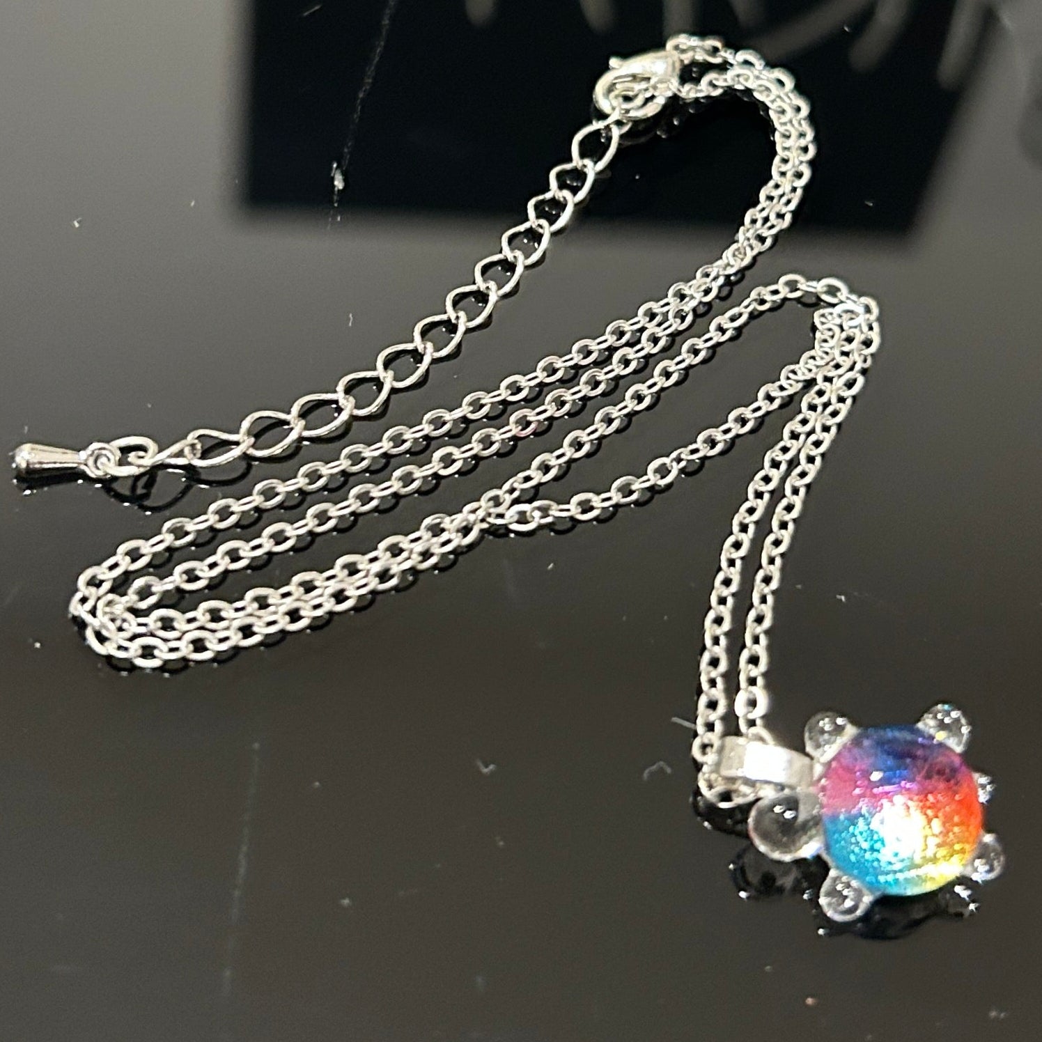 Handmade dichroic glass turtle pendant 1 inch showing color-shifting rainbow effects in blues purples oranges greens