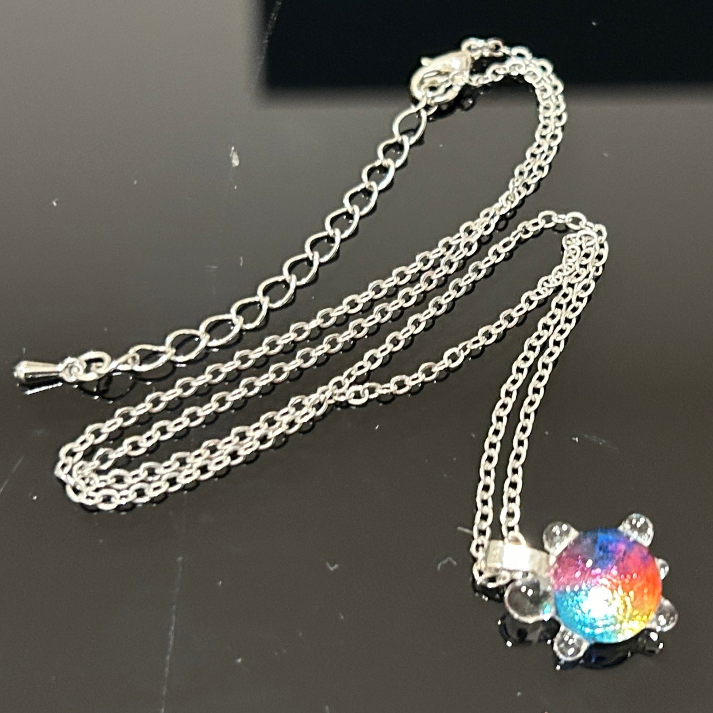 Handmade dichroic glass turtle pendant 1 inch showing color-shifting rainbow effects in blues purples oranges greens
