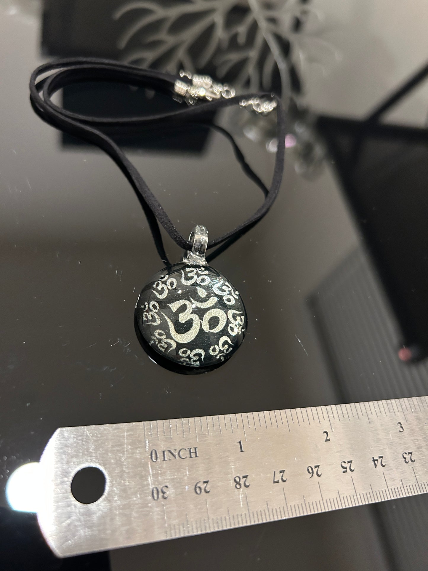 Handmade round black dichroic glass pendant with silver Om symbols sacred mantra yoga meditation spiritual jewelry on black satin cord necklace