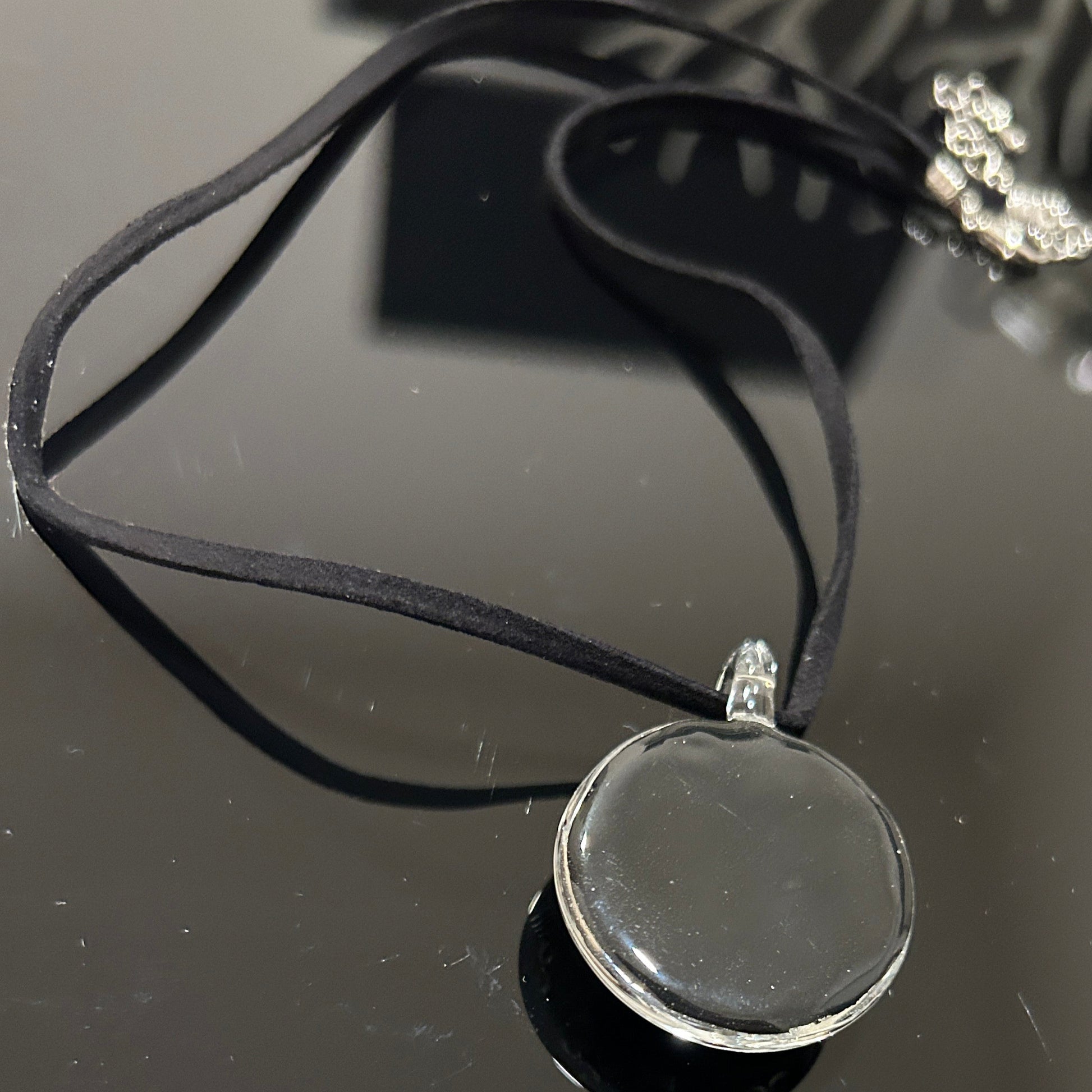 Handmade round black dichroic glass pendant with silver Om symbols sacred mantra yoga meditation spiritual jewelry on black satin cord necklace