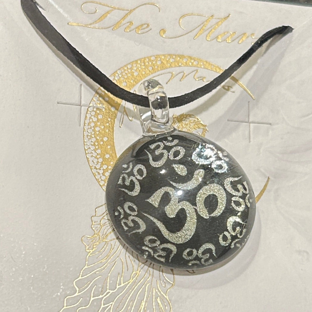 Handmade round black dichroic glass pendant with silver Om symbols sacred mantra yoga meditation spiritual jewelry on black satin cord necklace