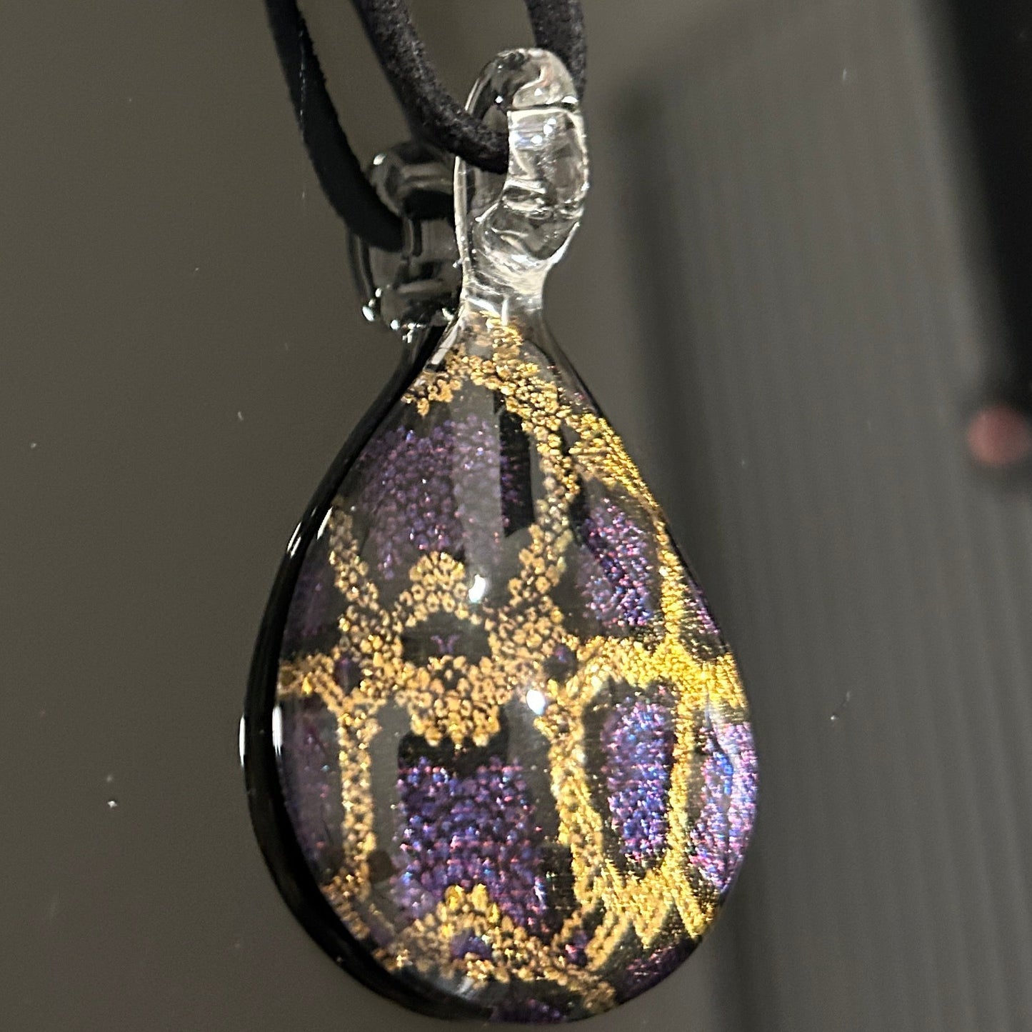 Handmade tree of life pendant in dichroic glass. 2 inches long, 1.25 inches wide. Blue and gold geometric design. Solid glass construction. 21" cloth cord included.