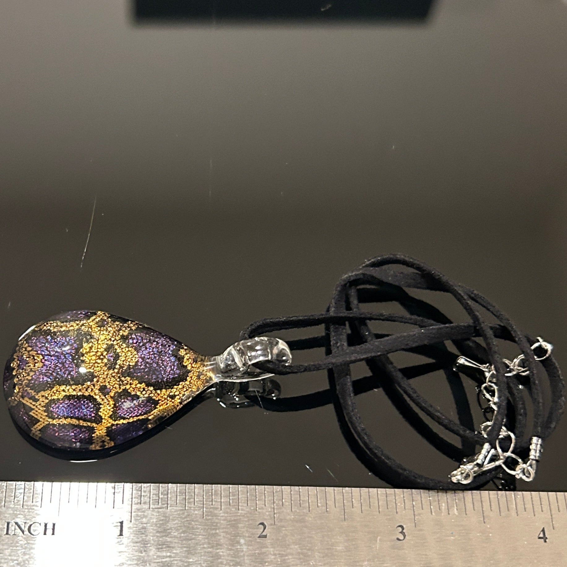 Handmade tree of life pendant in dichroic glass. 2 inches long, 1.25 inches wide. Blue and gold geometric design. Solid glass construction. 21" cloth cord included.