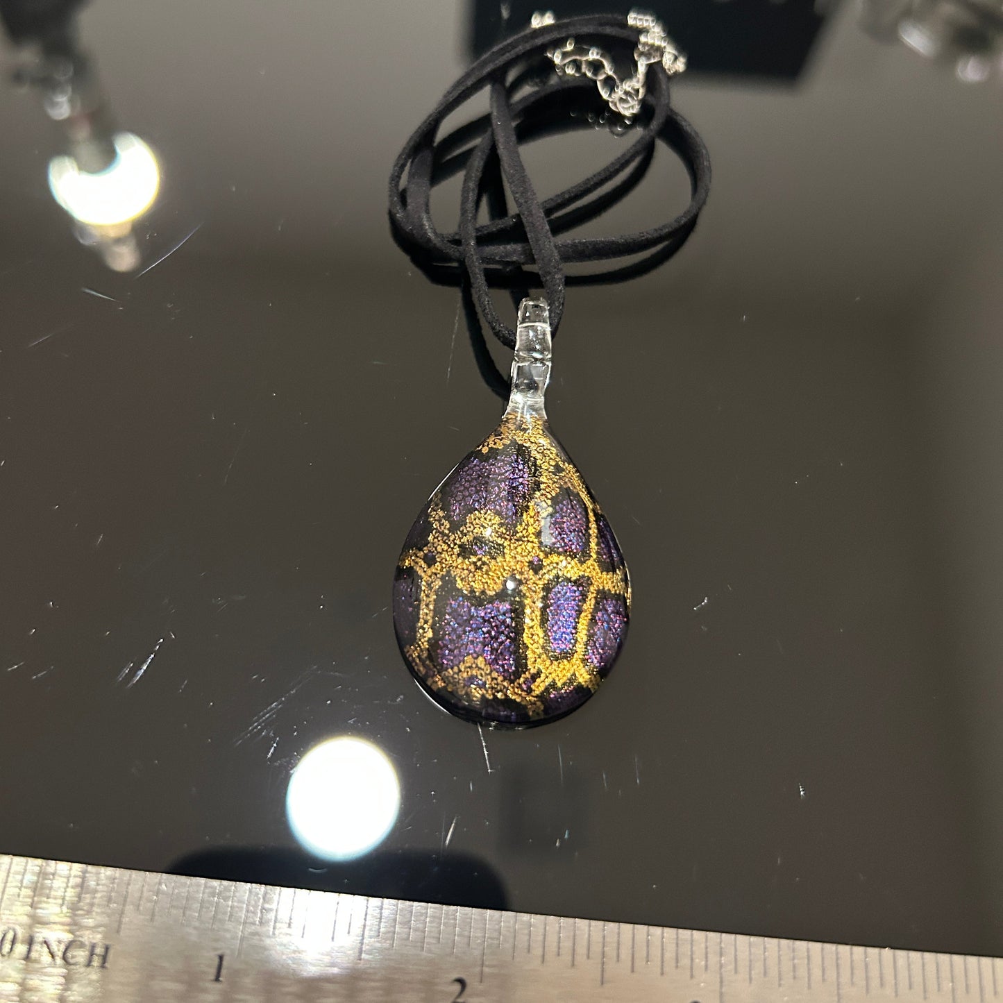 Handmade tree of life pendant in dichroic glass. 2 inches long, 1.25 inches wide. Blue and gold geometric design. Solid glass construction. 21" cloth cord included.