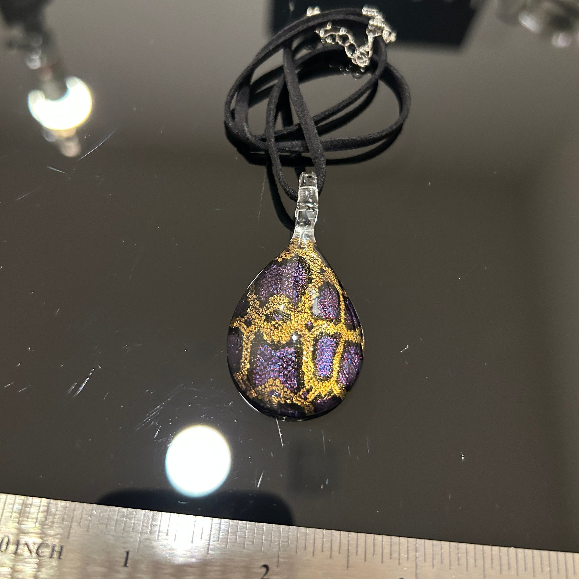 Handmade tree of life pendant in dichroic glass. 2 inches long, 1.25 inches wide. Blue and gold geometric design. Solid glass construction. 21" cloth cord included.